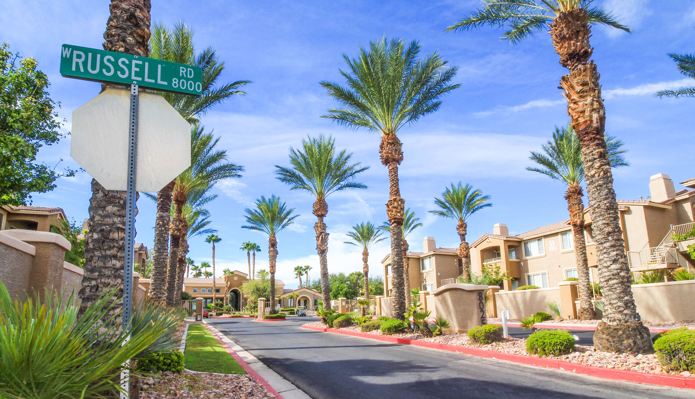 Entrance to San Tropez in Las Vegas showing a street lined with palm trees.